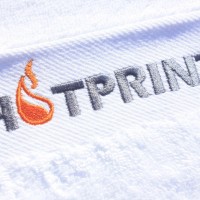 Полотенце с вышивкой логотипа в 2 цвета.